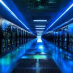 A modern data center interior with rows of servers illuminated by blue and green LED lights, representing high-performance web hosting infrastructure in 2026.
