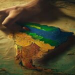 A photorealistic image showing a map of South America with the United States flag superimposed over Brazil, and a shadowy hand reaching down from the top, symbolizing intervention. No text or logos.
