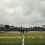 Photorealistic wide shot of a Mexican training facility with Iranian flags and football fields, surrounded by police tape and forensic investigators near a body outline, under a grey sky, no text