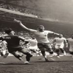 A photorealistic image of the 1950 World Cup match between USA and England at Estádio Independência in Belo Horizonte, Brazil. A black-and-white photo style showing players in old-fashioned kits, wi