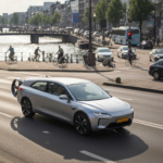 A photorealistic image of a modern amphibious car driving on a crowded city street, with a canal visible in the background. The car is sleek, silver, with retractable wheels and a propeller. Sunlight