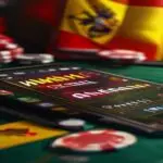 A photorealistic digital illustration of an online blackjack game interface, with cards, chips, and a 'Winamax' logo, displayed on a tablet placed on a table with the Spanish flag in the background, e